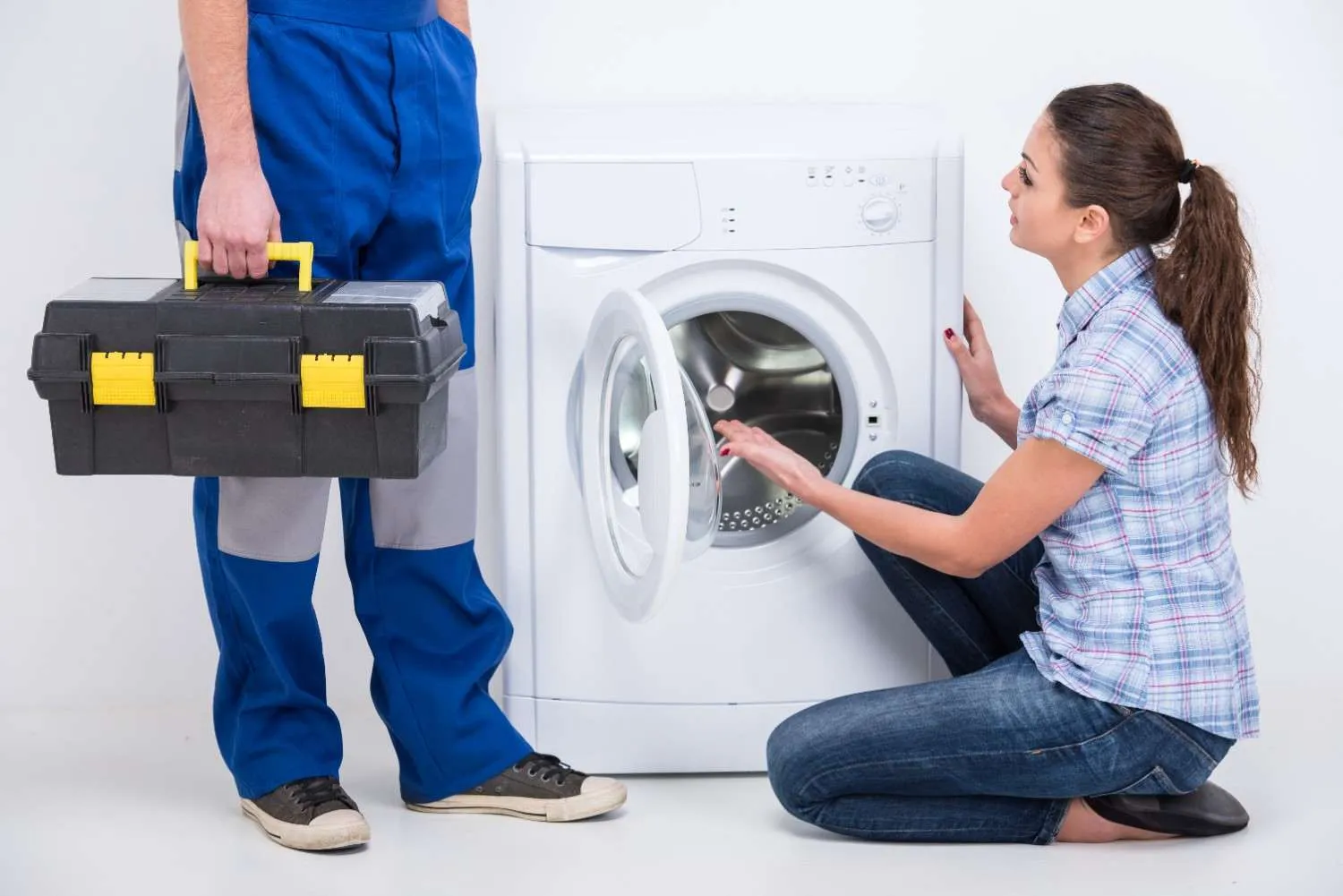 Repair worker with a toolbox beside a homeowner and a washing machine